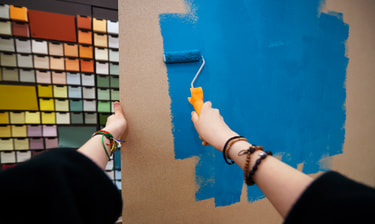Des mains peignent un mur en bleu Des mains peignent un mur en bleu